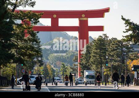 Una vibrante scena del Parco Okazaki che conduce al Santuario Heian-Jingu Grand Torii, circondato da vegetazione ed edifici sotto un cielo limpido. Okazaki Seishoji Foto Stock