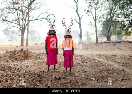 Uomini locali in gonne della tribù muria di cervi con abiti tradizionali con cappello di corno di cervo fatto a mano e ornamenti colorati, Chhattisgarh, india Foto Stock
