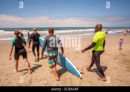 16 luglio 2016, Huntington Beach: Grazie per il suo servizio militare, un veterano (a destra) riceve una lezione di surf gratuita da un istruttore femminile (a sinistra) mentre camminano verso l'Oceano Pacifico a Huntington Beach, CA. (Credit Image: © Spencer Grant/ZUMA Press Wire) Foto Stock