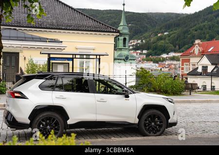 Bergen, Norvegia - 6 luglio 2024: SUV Toyota RAV4 parcheggiato vicino alla fermata dell'autobus Fredriksberg con vista sulla chiesa Foto Stock