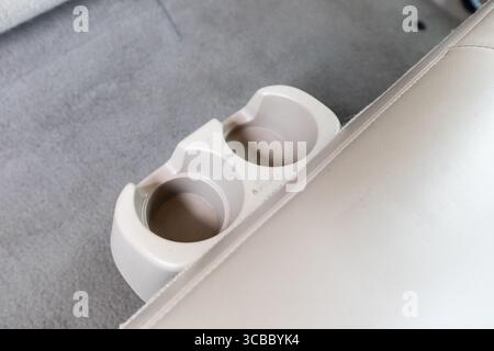 Immagine ravvicinata degli interni dei portabicchieri e dell'area della console centrale tra i sedili in pelle beige di un classico pick-up 4x4 americano. Foto Stock
