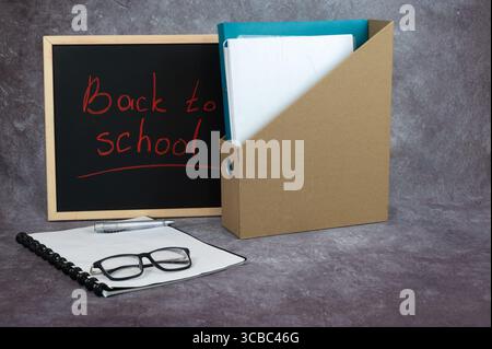 Una lavagna con le parole "ritorno a scuola" scritte splendidamente su di essa Foto Stock