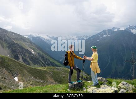 La coppia di escursionisti tiene le mani sulla cima della montagna con vista alpina in Austri Foto Stock