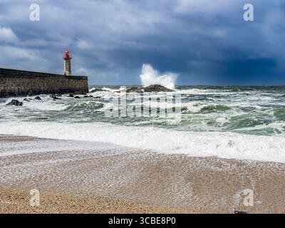 Onde che si infrangono al Farolim da barra do Douro, faro a Foz do Douro, Porto, Portogallo. Foto Stock