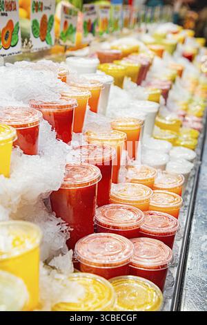 Frullato multicolore, coperto di ghiaccio, in un chiosco a Barcellona mercado de la boqueria Foto Stock