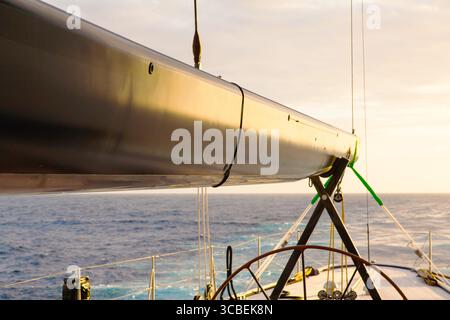 Primo piano di uno yacht a vela in mare al tramonto. Foto Stock