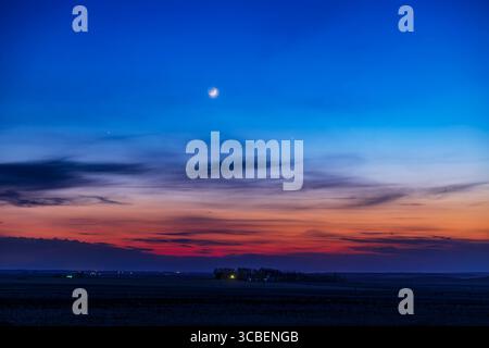 2 maggio 2022, Alberta, Canada: La luna crescente di due giorni con la Terra, sopra mercurio a destra, poi 4 giorni dopo il suo più grande allungamento dal Sole, nel cielo serale del 2 maggio 2022. La stella Aldebaran è a sinistra, e sotto mercurio a destra si trovano le Pleiadi, appena visibili al crepuscolo e nelle nuvole sottili. Si tratta di un'esposizione singola di 1,6 secondi con l'obiettivo Canon RF28-70mm a 70mm e f/2,8 e Canon Ra a ISO 100. Portato da casa in Alberta a 51Â di latitudine nord. Un leggero effetto bagliore Orton aggiunto con Luminar Neo. (Immagine di credito: © Alan Dyer/VW Pics via ZUMA Press Wire) Foto Stock