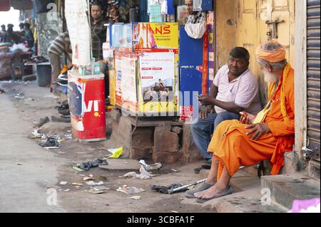 Strade di Mumbai, Masjid Bunder, India, gente seduta davanti ad una porta del mercato, baraccopoli, 06.03.2025 Foto Stock
