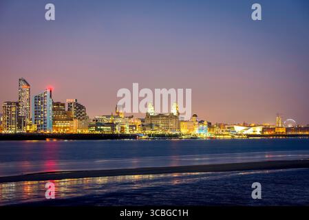 Skyline di Liverpool di notte con il lungomare illuminato e i riflessi sul fiume Mersey. Foto Stock