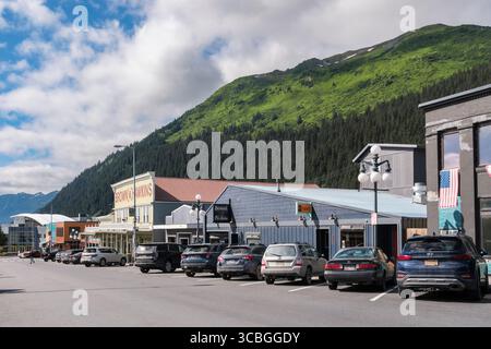 Auto parcheggiate in strada con negozi nella vecchia città della costa meridionale dell'Alaska con vista sul Sealife Centre. 3rd Avenue, Seward, Penisola di Kenai, Alaska, Stati Uniti Foto Stock