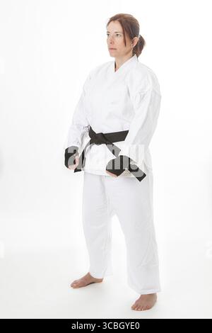 Donna nella sua fortie, che indossa protec per le mani nere e un'uniforme di arte marziale, in prima posizione Foto Stock