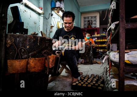 10 febbraio 2023, Bangkok, Bangkok, Tailandia: I lavoratori montano le scarpe in un negozio di scarpe nella zona est di Bangkok. (Immagine di credito: © Matt Hunt/ZUMA Press Wire) Foto Stock