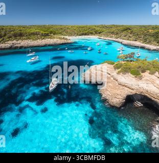 Vista aerea degli yacht nella baia turchese vicino alle scogliere di Maiorca Foto Stock