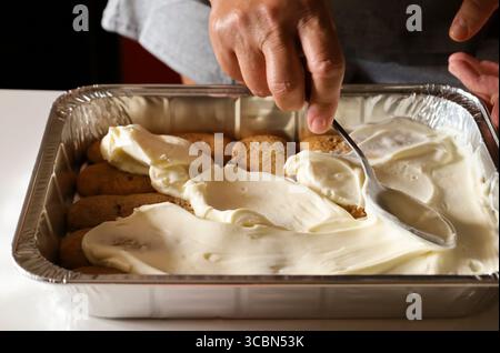 Donna che prepara il Tiramisu dessert in cucina Foto Stock