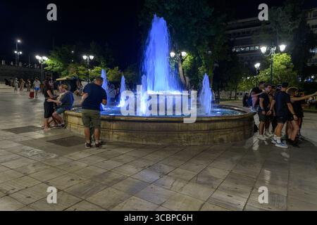 Scena notturna con persone alla Fontana nel centro di Atene, in Grecia Foto Stock