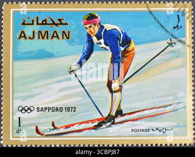 Francobollo cancellato stampato da Ajman, che mostra lo sci di fondo e promuove i Giochi Olimpici invernali a Sapporo 1972, circa 1970. Foto Stock