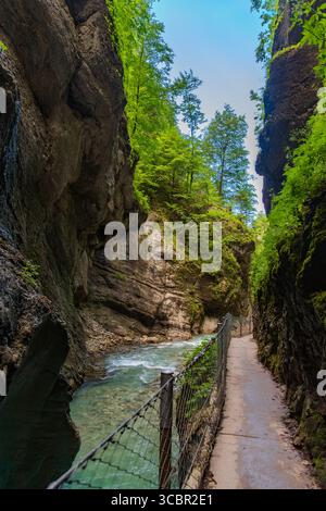 Stretta passerella scavata sulla scogliera lungo un torrente turchese all'interno della gola di Partnachklamm, Garmisch-Partenkirchen, Baviera. Uno splendido pass naturale Foto Stock