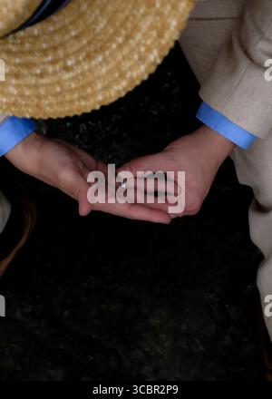 Una persona che tiene in mano un anello. Foto Stock