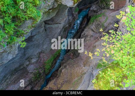 Vista aerea da un ponte sospeso che si affaccia su uno stretto torrente turchese che attraversa una profonda gola rocciosa vicino a Partnachklamm, Garmisch-Partenkirch Foto Stock