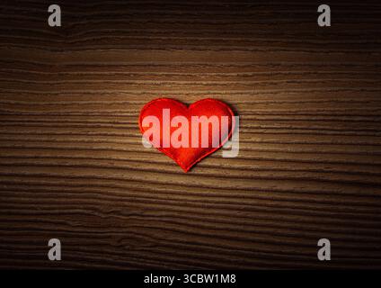 Foto di vignettatura della forma del cuore rosso sul primo piano dello sfondo del pannello di legno Foto Stock