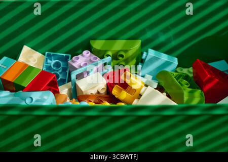 Tyumen, Russia - 8 luglio 2025: Mattoncini colorati Lego disposti in un contenitore verde che mostra una creatività infinita Foto Stock