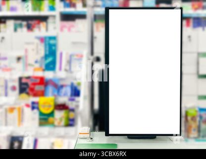 Farmacia. Il pannello bianco vuoto vuoto del display insegna pubblicitaria contro gli scaffali sfocati nel negozio medico. Farmaci vendita pillole, vaccini e salute c Foto Stock