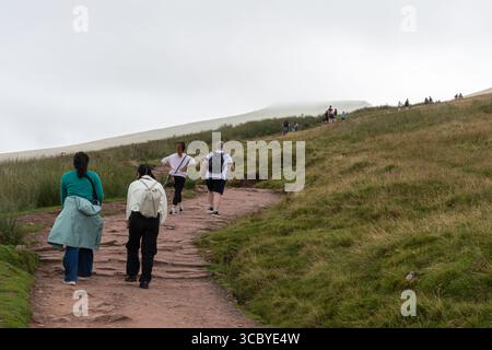 Persone che camminano nel Brecon Beacons National Park su un sentiero per Pen Y fan da Pont AR DAF, la vetta più alta del parco, Galles, Regno Unito Foto Stock