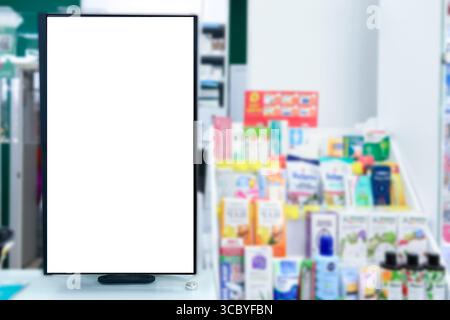Farmacia. Il pannello bianco vuoto vuoto del display insegna pubblicitaria contro gli scaffali sfocati nel negozio medico. Farmaci vendita pillole, vaccini e salute c Foto Stock