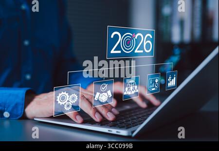 2026 obiettivi aziendali e concetto di pianificazione strategica. Uomo d'affari che utilizza un notebook con 2026 icone di obiettivi e strategie, che rappresentano gli obiettivi futuri, aziende Foto Stock