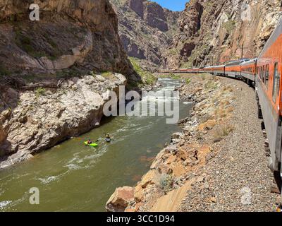 Canon City, Colorado, USA - 22 maggio 2025: Vista panoramica di un treno sulla Royal Gorge Route Railroad lungo il fiume Arkansas con kayak Foto Stock
