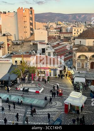 Vista dell'ora d'oro di Monastiraki Plaza ad Atene, Grecia, catturando l'atmosfera urbana vibrante e l'architettura storica. Foto Stock
