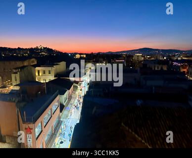 Vista del tramonto sui tetti di Atene, Grecia, con un vivace paesaggio urbano e un orizzonte luminoso. Foto Stock