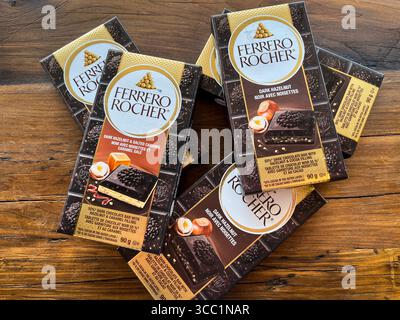 Vaughan, Ontario, Canada - 28 luglio 2025: Barrette di cioccolato fondente Ferrero Rocher su sfondo di legno Foto Stock