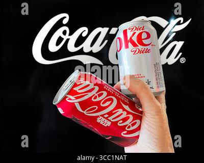 Vaughan, Ontario, Canada - 28 luglio 2025: Lattine in alluminio Coca Cola e Diet Coke davanti al logo Coca Cola Foto Stock