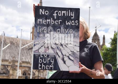 Londra, Regno Unito. 09 agosto 2025. Un manifestante tiene in mano un cartello raffigurante famiglie morte a Gaza durante la manifestazione in Piazza del Parlamento. Centinaia di persone si sono riunite per dimostrare sostegno al gruppo di attivisti Palestine Action, che è stato vietato ai sensi della legge antiterrorismo. Credito: SOPA Images Limited/Alamy Live News Foto Stock