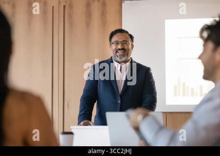 Uomo d'affari maturo e felice in tuta formale soddisfatto della presentazione del campo Foto Stock