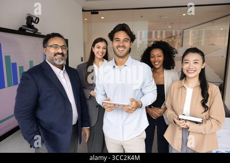 Cinque diversi professionisti del settore multiculturale in piedi sorridenti guardando la fotocamera Foto Stock