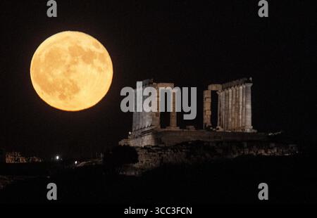 Atene, Grecia. 9 agosto 2025. Una luna piena sorge sull'antico Tempio di Poseidone a Capo Sunio a Sounion, in Grecia, il 9 agosto 2025. Crediti: Marios Lolos/Xinhua/Alamy Live News Foto Stock