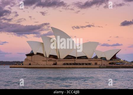 Sydney Opera House tramonto sulle acque del porto di Sydney, Bennelong Point, Sydney, Australia Foto Stock