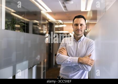 Giovane e fiducioso proprietario di un'azienda latina che posa in un ufficio elegante Foto Stock
