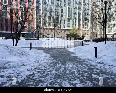 Ucraina, Kiev - 18 febbraio 2025: Terrapieno invernale nel parco di Kiev. River Mall Park. Vicino ai nuovi edifici a più piani. Foto Stock