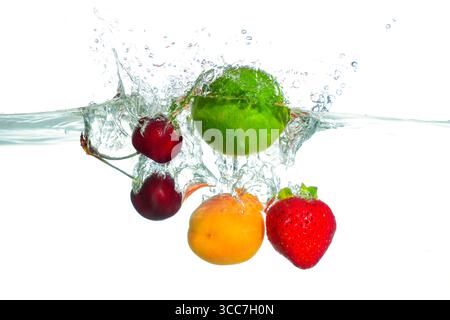Frutti vivaci, tra cui ciliegie dolci, lime verde, albicocca e fragola che spruzzano in acqua limpida, mostrando movimento dinamico e rinfrescante Foto Stock