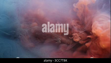 Acqua di fumo. Vapore nuvoloso. Inchiostro blu rosa arancio sfocato goccia di liquido che galleggia su uno sfondo astratto sott'acqua acrilico artistico. Foto Stock