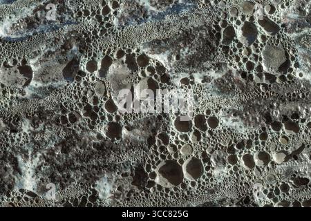 Consistenza rocciosa ruvida. La roccia è grigia e ha molti buchi. Sfondi astratti full frame Foto Stock