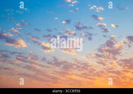 Durante il tramonto, il cielo diventa di colori brillanti e le nuvole riflettono sfumature di giallo, arancione e rosa. Foto Stock