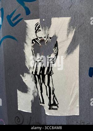 Flensburg, Schleswig-Holstein Beschädigter Streetart-Sticker a Flensburg, Holm, zeigt eine Figur in gestreifter Kleidung. DAS herausgerissene Element erinnert an eine Friedenstaube ein etabliertes Symbol für Hoffnung und Versöhnung. Im Kontext von Gaza und dem aktuellen Krieg steht die abgerissene Taube für die verletzte Sehnsucht nach Frieden: Die Zerstörung des Motivs spiegelt die anhaltende Gewalt und das Fehlen einer friedlichen Lösung Wider. Dadurch wird die Kunst zum Ausdruck politischer Ohnmacht im Nahost-Konflikt. Aufnahme von 10.08.2025, Flensburg, *** Flensburg, Schleswig Holstein D Foto Stock