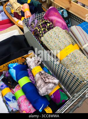 I resti del tessuto sono disposti in modo ordinato in un cestello. Il filmato e il prezzo sono scritti Foto Stock