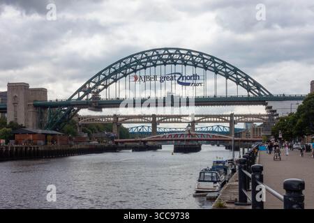 Vista lungo la banchina lungo il fiume Tyne a Newcastle guardando verso il ponte Tyne. Foto Stock
