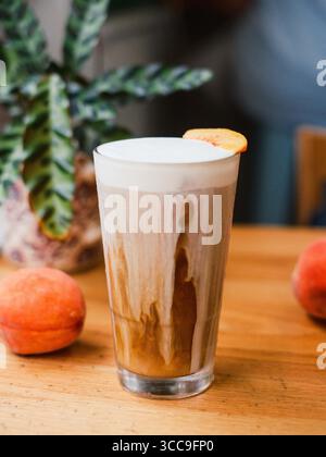 Tall Peach Cold-Foam Coffee with Whole Peaches Foto Stock