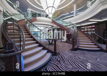 Grande lampadario sopra le scale curve nell'atrio della nave da crociera Seven Seas Explorer, Oceano Pacifico, Alaska, Stati Uniti Foto Stock